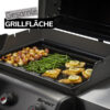 Ein geöffneter Gasgrill mit einer Grillplatte, auf der gewürfelte Kartoffeln, grüne Bohnen und Fischfilets mit Zitronenscheiben gegrillt werden. Auf dem Deckel steht der Text „Gesamte Grillfläche“. Der Grill ist mit dem Schriftzug „Spirit“ gekennzeichnet.