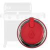 Ein roter Grill-Drehknopf mit silbernem Rand und Flammensymbol in der Mitte, dargestellt vor einem transparent eingeblendeten Weber-Gasgrill mit vier Reglern.