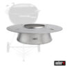 Ein silberfarbener Weber Charcoal Heat Controller, ein Holzkohle-Temperaturregler für Kugelgrills. Im Hintergrund ist ein verschwommener Umriss eines Weber Holzkohlegrills zu sehen. Unten rechts ist das Weber-Logo abgebildet.